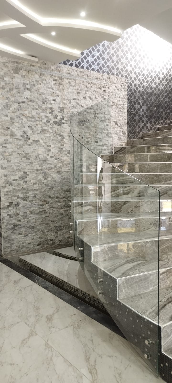 Escalera con barandal curvo de cristal templado